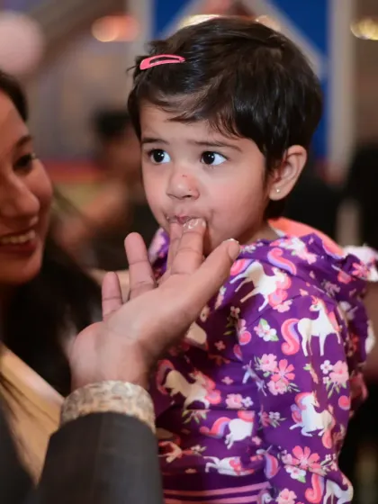 A sweet moment of a child tasting birthday cake frosting. These are the simple, joyful memories of childhood.