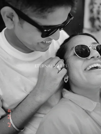 A playful, candid moment from a pre-wedding shoot. Their sunglasses and wide smiles capture a cool, modern love story that is full of fun and laughter.