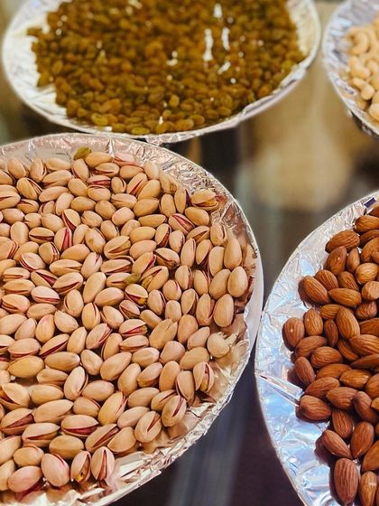 An assortment of premium dry fruits including pistachios, almonds, cashews, and raisins. This is an excellent option for a 'Baarath Swagath' (welcoming the groom's procession) or as a healthy snack counter.