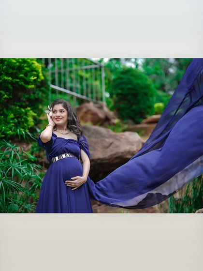 An artistic shot of a mom-to-be in a flowing blue gown. The movement of the fabric creates a sense of freedom and grace in this beautiful outdoor setting.