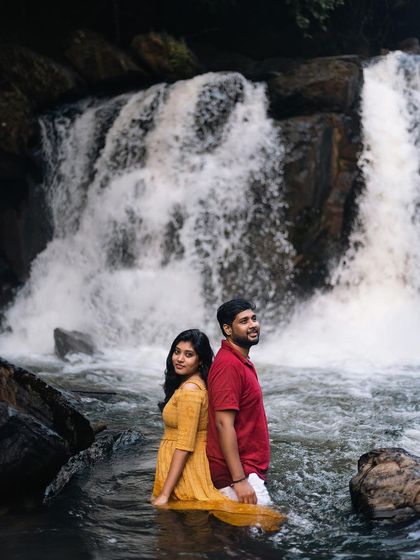 A powerful portrait of the couple standing back-to-back in front of a rushing waterfall, symbolizing their strength together.