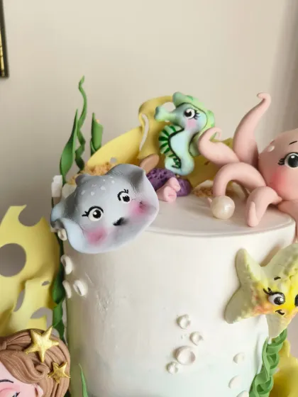A cute stingray and seahorse, peeking out from the top of the cake.