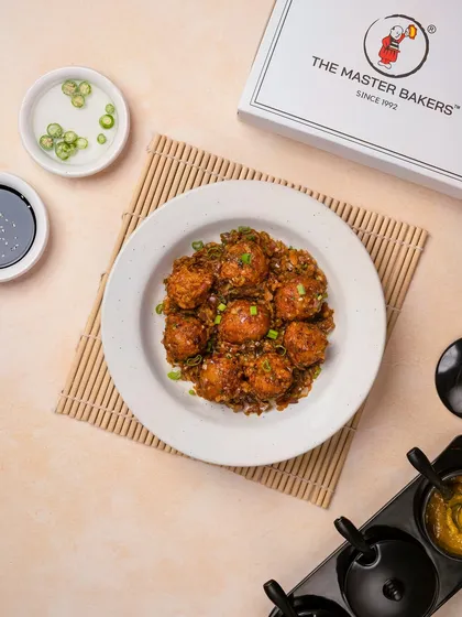 Our dry Vegetable Manchurian, featuring crispy vegetable balls tossed in a savory and tangy sauce with onions and spring greens. It's a perfect appetizer or side dish.
