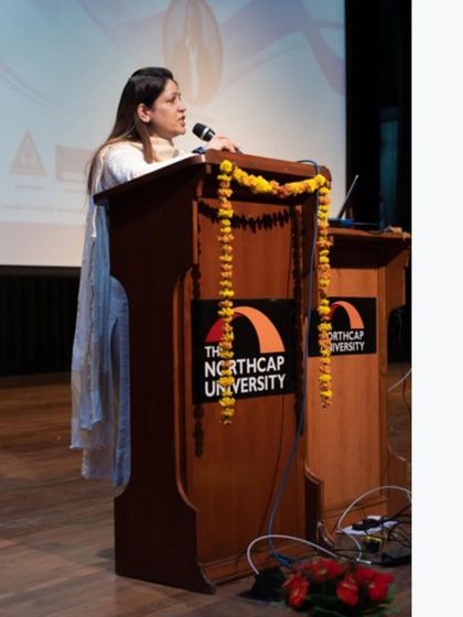 At the podium at The Northcap University, decorated with marigolds, a warm traditional welcome.