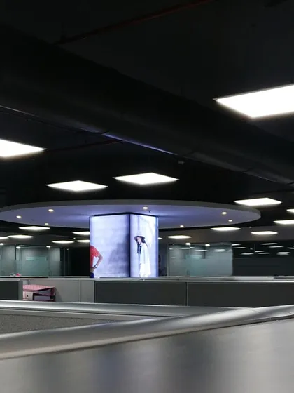 This perspective across the Skechers office cubicles shows the thoughtful lighting design. The large circular fixture complements the central display column, creating a cohesive and well-lit workspace.