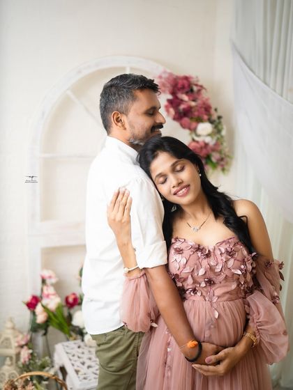 A quiet, tender moment between the expecting couple. The mother-to-be rests her head on her husband's shoulder, a picture of peace and trust.