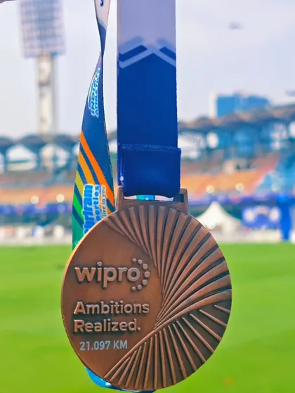 The Wipro Bengaluru Half Marathon medal, a symbol of ambition realized. We believe in setting goals together, like this couple who trains with us and celebrates each other's personal bests.