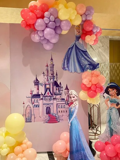 A detail shot of the princess party backdrop, showing the Disney castle illustration and cutouts of Elsa and Jasmine.