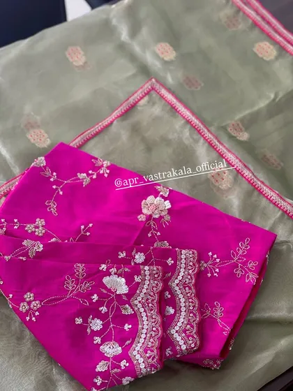 A beautiful pink blouse with delicate white and silver floral embroidery, paired with a soft olive green organza dupatta.