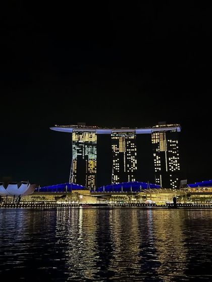 A postcard from Marina Bay, Singapore. This iconic shot captures the stunning architecture and vibrant nightlife of the city, creating aspirational travel content.