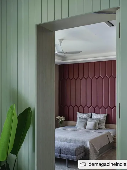 A peek into a bedroom from the hallway, revealing the dramatic red upholstered headboard that serves as a powerful focal point.