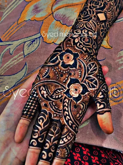 A close-up of a single hand from a bridal set, held by another person to showcase the design.