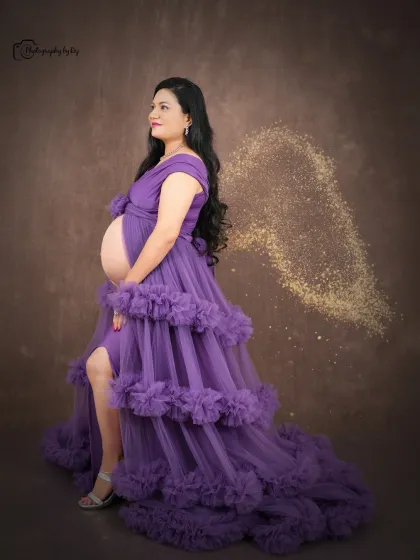 A magical studio portrait with edited-in golden fairy wings, adding a touch of fantasy to this maternity shoot.