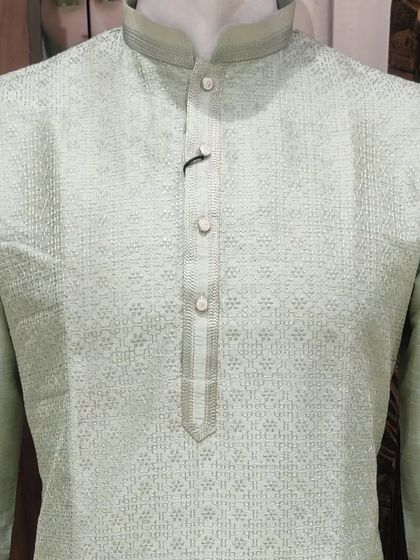 A light mint green kurta with self-color embroidery. The subtle texture and fresh color make this a perfect choice for a summer wedding event.