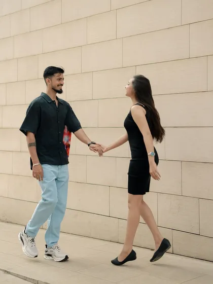 A playful, walking shot against a modern architectural wall. I often guide couples into simple actions like this to help them relax and capture their natural movement and interaction.