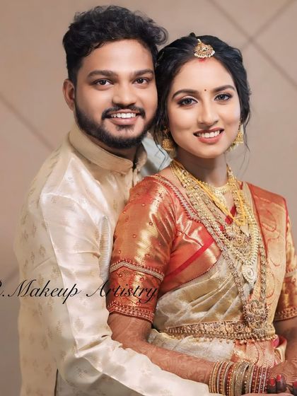 A lovely couple portrait. The bride's makeup is soft and radiant, complementing her traditional gold and white saree.