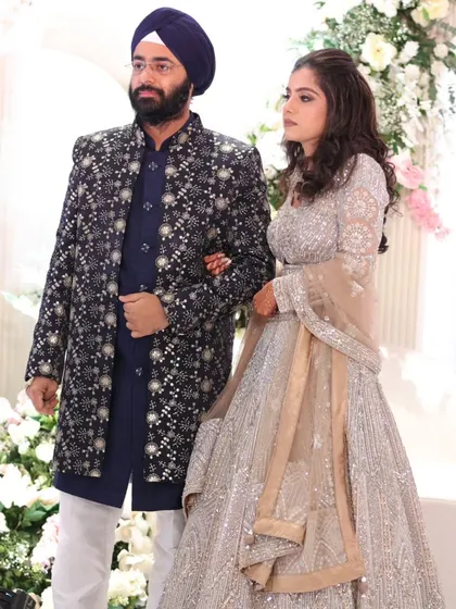Making an entrance together. This couple shines in their coordinated designer outfits, creating a captivating visual of love and happiness on their special night.