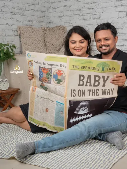 A fun and creative pregnancy announcement! We use custom props like this "Baby is on the way" newspaper for a unique and playful couple's photo.