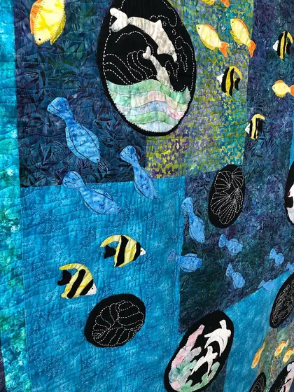 A detail shot of the sea quilt, showing the variety of fish and the sashiko-style stitching.