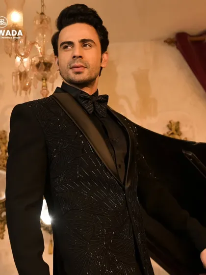 The black sequined tuxedo with a dramatic cape, adding a touch of theatrical flair. This is a showstopper look for a grand entrance.