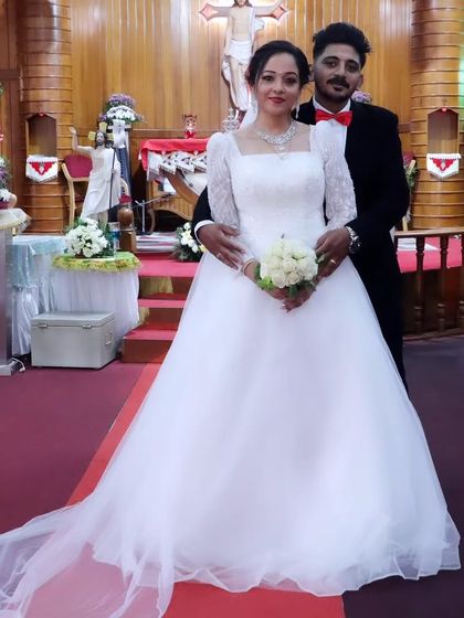 The happy couple. It's an honor to see my creation as part of such a beautiful union. The gown's classic silhouette and long train are perfect for a church wedding.