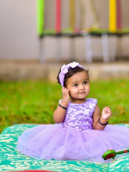 A quiet, thoughtful moment during an outdoor session. I aim to capture the full range of your baby's expressions, not just the smiles, to create a complete and honest portrait of who they are at this stage.