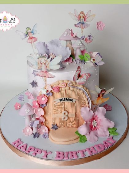 An enchanting fairy-themed cake for Yashika's 3rd birthday, featuring a fairy door, whimsical mushrooms, and fluttering fairies.
