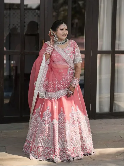 The perfect blend of tradition and grace. This classic bridal look features soft glam makeup and a floral bun, enhanced by a traditional maang tikka.