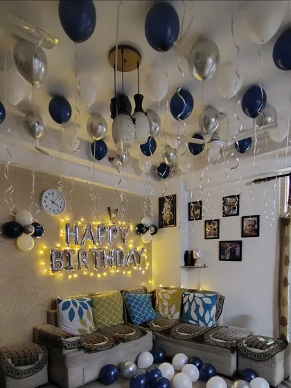A wider view of the navy and silver birthday room decoration, showing balloons on the ceiling as well.