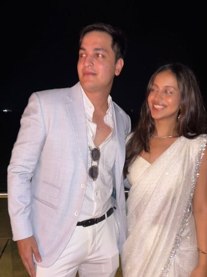 The client and his partner, perfectly styled for an evening event. The light blue linen jacket is a versatile piece that pairs effortlessly with white trousers for a sharp, celebratory look.