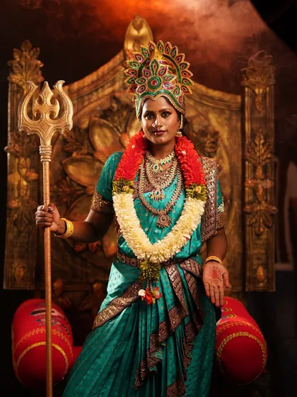 A close-up portrait of the Devi costume, showing the ornate crown and traditional makeup. I work with professional makeup artists to complete the transformation.