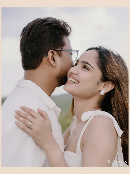 A beautiful, happy close-up of Pooja and Gaurav, with the rolling green hills of Udaipur creating a soft, romantic background.