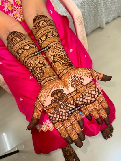 This bridal design is a celebration of tradition, featuring majestic peacocks on the palms and intricate architectural domes on the arms.