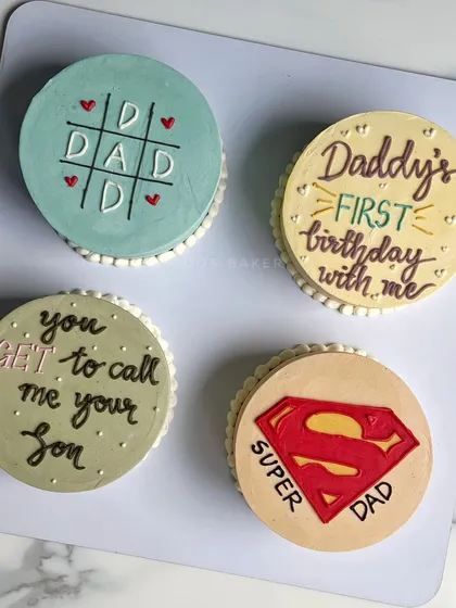 A collection of mini cakes perfect for Father's Day. Designs include a "Super Dad" logo, a tic-tac-toe board, and sweet messages for the best dad.