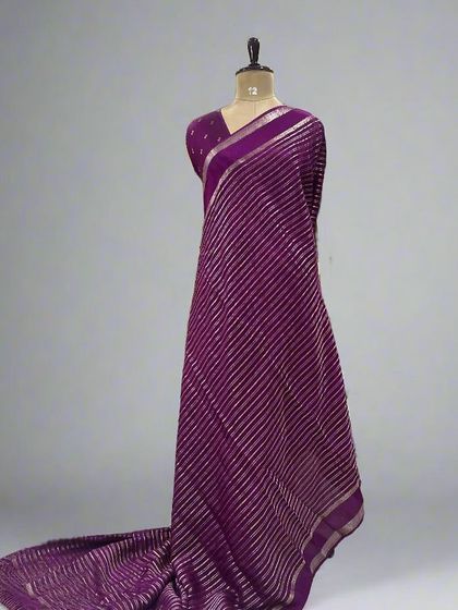 A mannequin draped in a beautiful purple saree with silver stripes.