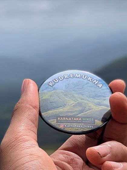 Our Kudremukha badge held against the beautiful, layered hills. A memory you can take home with you.