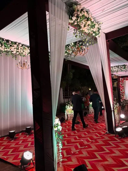A side view of the reception passage, showing guests walking through the beautifully lit and decorated space.