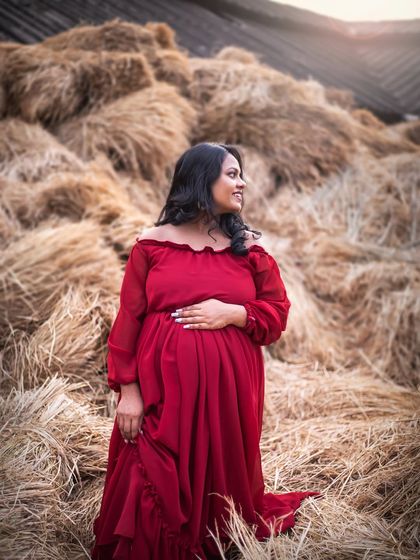 Using elements of the landscape, like these haystacks, adds a rustic and unique texture to outdoor maternity photos.