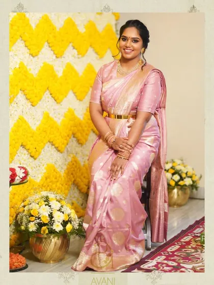 A client looking lovely in a pink Banarasi silk saree. Her matching pink blouse is simple and elegant, perfect for a daytime event.