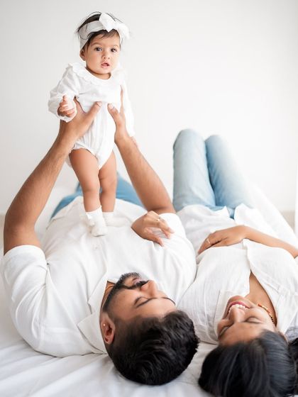 A family portrait with the baby being held up in the air.