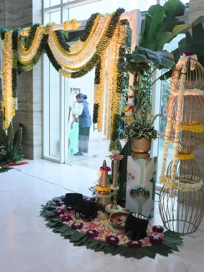 This entrance combines traditional marigold garlands with modern elements like birdcage-style decor and a floor of banana leaves, creating a unique fusion look.