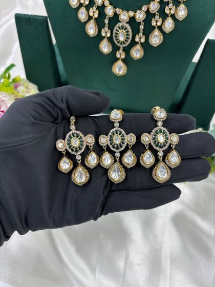 A close-up of the earrings and tikka from our Moissanite Kundan set. This highlights the fine craftsmanship and the combination of red and white stones.