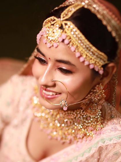 The bride's serene expression is captured perfectly. The soft pink makeup and delicate jewelry create a look of timeless beauty.
