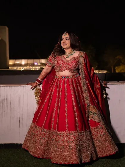 A full-length view of Shivali's timeless wedding look. The rich red color and intricate gold embroidery are classic choices for a bride who wants to honor tradition while looking stunning.