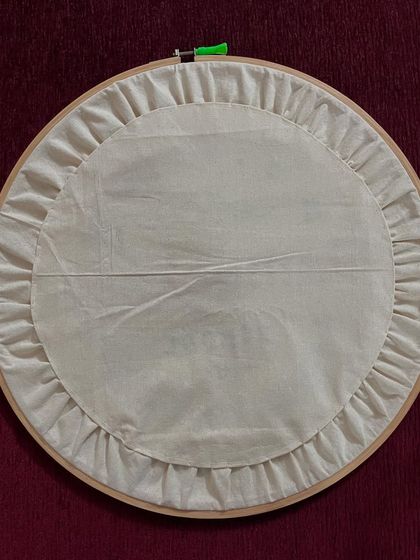 The back of the embroidered logo hoop, showing the neat, gathered finish. I always teach my students that the reverse side of the work should be as clean as the front.