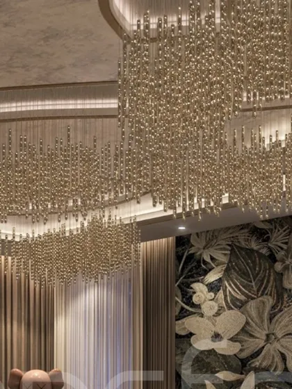 A close-up of the magnificent cascading chandelier against the floral wallpaper. This juxtaposition of structured light and organic pattern creates a powerful visual statement.