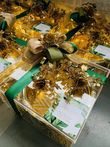 Our festive hampers are a feast for the senses. This Diwali hamper, presented in a clear acrylic box, is filled with light and adorned with rich green and gold details, showcasing our ability to create modern, luxurious gifts that honor tradition.
