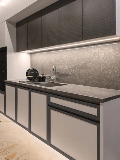 A closer look at the sink area, showcasing the dark textured upper cabinets and integrated under-cabinet lighting. The design is minimal, sleek, and perfect for a modern home.