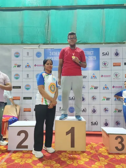 One of our dedicated athletes stands proudly on the number one podium after winning gold. This is the result of countless hours of training and dedication in our kickboxing program.