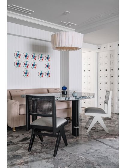 The dining nook is our favorite spot in Frenchie Haus. It’s a cozy corner with a marble-topped table, a comfortable banquette, and a wall of 'I Love Me' plates, creating a space that has a magnetic, inviting pull.